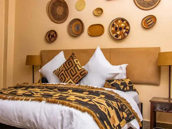 Twin bedroom at Acacia Tree Lodge with woven wall baskets and kikoi throws