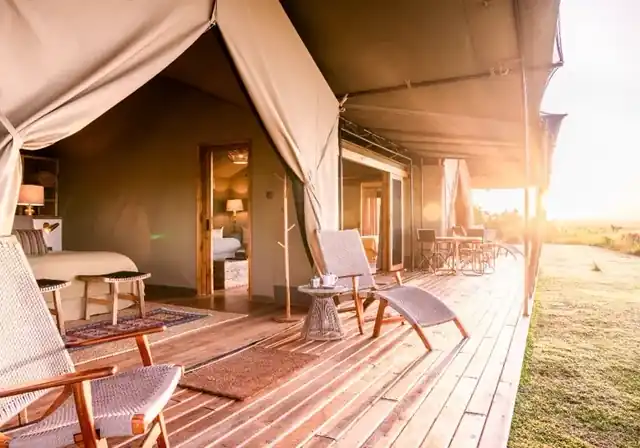 Governors' Camp tent exterior with private wooden deck at golden hour