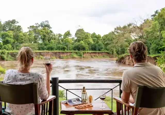 Guests enjoying wine overlooking the Mara River at Governors' Camp