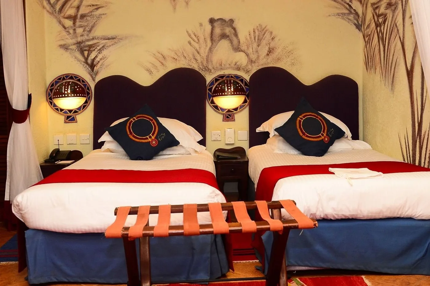 Twin bedded room at Amboseli Serena Safari Lodge with Maasai beaded lamps and wall murals