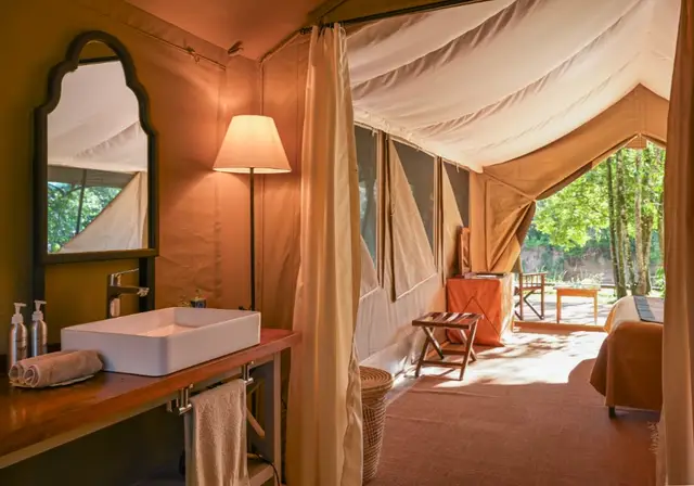 En-suite bathroom inside a Governors' Camp tent with river views through open canvas