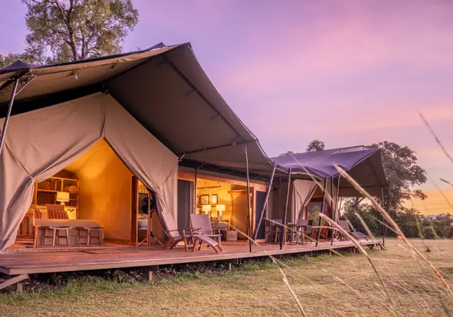 Governors' Camp family tent glowing at sunrise with a private wooden deck